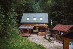 a wooden building with a roof and a flag at Apartament w lesie, na odludziu z widokami in Jaszczurowa