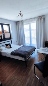 a bedroom with a large bed and a large window at Sunset Beach in Sarbinowo