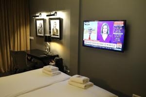 a hotel room with a television and a bed at Grand Hotel Alkmaar in Alkmaar