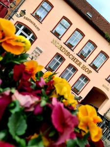 ein Gebäude mit Blumen davor in der Unterkunft Nordischer Hof in Krakow am See