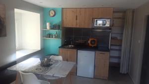 a small kitchen with a table and a microwave at Studio chaleureux vue sur le massif du vercors . in Alixan