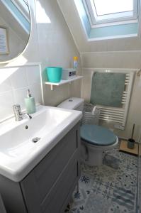 a bathroom with a sink and a toilet and a window at Appt cosy - 300m plage-proche Arromanches et Bayeux in Asnelles