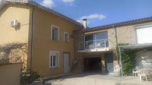 a house with a patio and a balcony at Studio chaleureux vue sur le massif du vercors . in Alixan