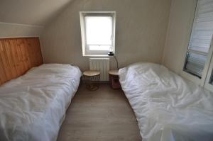 um quarto com 2 camas, uma mesa e uma janela em Appt cosy - 300m plage-proche Arromanches et Bayeux em Asnelles