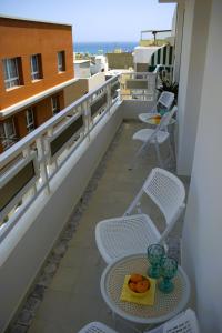 a balcony with chairs and a table with oranges on it at AMBER APARTMENTS - SUNNY STUDIO in Morro del Jable