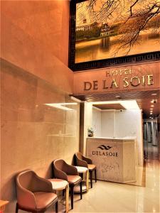 a row of chairs in a lobby with a sign at DE LA SOIE Hotel & Travel in Hanoi