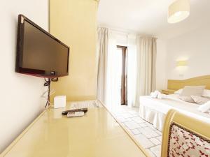 a bedroom with a tv on the wall and a bed at B&B La Vigna in Carovigno