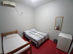 Habitación pequeña con 2 camas y espejo. en Discovery hostel, en Manaus