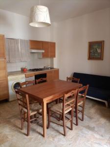 a kitchen with a wooden dining table and chairs at Villa Felice in Porto Cesareo