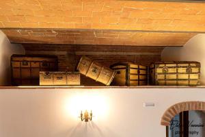 une étagère avec des malles au-dessus d'un mur dans l'établissement Partino ArtHouse, à Palaia