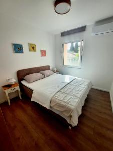sypialnia z dużym łóżkiem i oknem w obiekcie Montenegro Sea Pearl Apartments Petrovac w Petrovacu na Moru