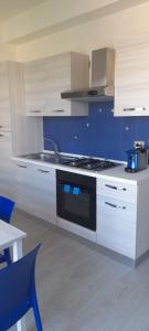 a kitchen with white cabinets and a stove top oven at Jak's Home Laigueglia in Laigueglia