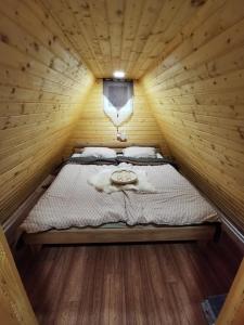 um quarto com uma cama num chalé de madeira em Glamping hišice Orlič em Muta