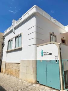 un bâtiment blanc avec une porte bleue dans l'établissement Casa Algarbe, à Faro