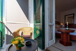 Hotel Dalmacija في فيلا لوكا: شرفة مع طاولة وغرفة مع سرير
