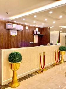 a lobby with a reception counter with red ribbonbons at حكاية عبير للأجنحة الفندقية in Jeddah