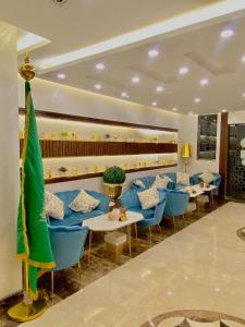 a restaurant with blue chairs and tables in a room at Hykayat Abeer Served Apartments in Jeddah