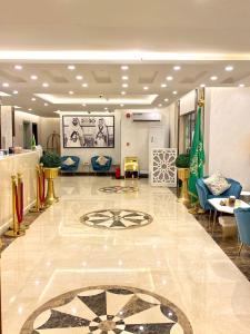 a lobby with blue chairs and a large tile floor at Hykayat Abeer Served Apartments in Jeddah +44 photos