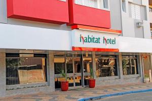 a restaurant with a sign on the front of a building at Habitat Hotel de Leme Ltda in Leme