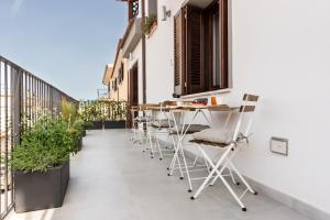 un balcone con tavoli e sedie in un edificio di Tortora bed and breakfast a Galtellì