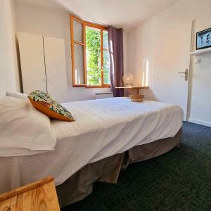 a bedroom with a bed with a pillow on it at Le Terminus in LʼArbresle