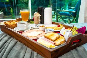 ルミアルにあるPousada Dom Dimitriのテーブルの上に朝食用の食品とドリンクのトレイ