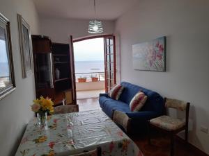 uma sala de estar com um sofá azul e uma mesa em Brezza Marina IUN R6124 em Castelsardo