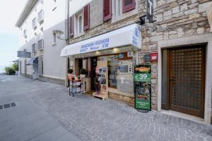 a store on the side of a building on a street at Appartamenti Anna in Sirmione