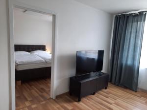 a bedroom with a bed and a mirror and a television at apartmán Filloména in Liptovský Mikuláš