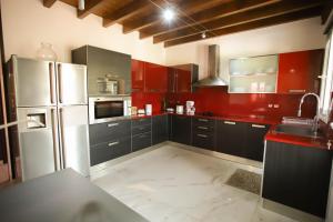 a kitchen with red cabinets and a white refrigerator at Moon studios in Lygia