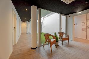 a hallway with two chairs and a large window at Uporto House Residence in Porto