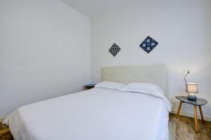 - une chambre blanche avec un lit blanc et une table dans l'établissement Appartamento Cesare, à Sirmione