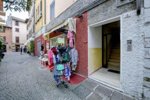 un magasin dans une rue où des vêtements sont exposés dans l'établissement Appartamento Cesare, à Sirmione