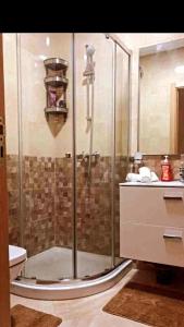 una ducha de cristal en un baño con lavabo en Magnifique Appartement balnéaire à Bouznika avec piscine, en Bouznika