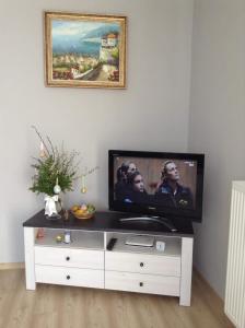a flat screen tv sitting on top of a white entertainment center at Villa Klif 10 in Trzęsacz