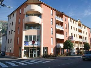 a large brick building on a city street with a stop sign at Superbe appart avec de parking gratuit sur place in Lourdes