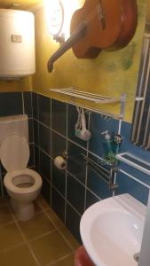 a bathroom with a toilet and a guitar on the wall at Airport Jackson Loft in Catania