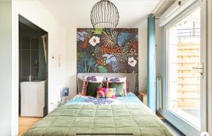 1 dormitorio con 1 cama y una gran pintura en la pared en Le Garden Studio avec terrasse et parking centre ville, en Rouen