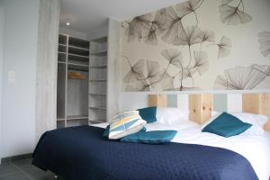 a bedroom with a large bed with blue sheets and pillows at Le Domaine de Louise in Seigy