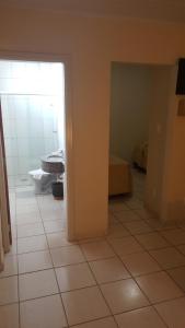 a room with a bathroom with a tiled floor at Habitat Hotel de Leme Ltda in Leme