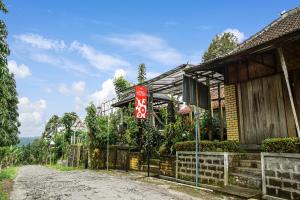 ein Haus mit einem Schild am Straßenrand in der Unterkunft OYO Homes 90984 Kampung Wisata Ekologi Puspa Jagad in Blitar