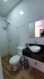 uma casa de banho com um WC, um lavatório e um espelho. em Studio pé na areia com 2 quartos sala cozinha em Trairi