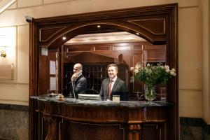 Un uomo seduto a un tavolo di fronte a uno specchio di Grand Hotel Wagner a Palermo