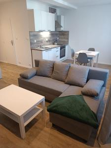a living room with a couch and a table and a kitchen at Sky Thermal Apartment in Karlovy Vary
