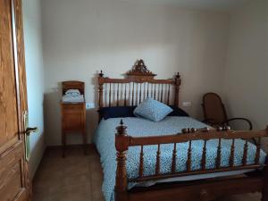 ランポーヤにあるCasa Mas del Vedellのベッドルーム1室(木製ベッド1台、青い掛け布団付)