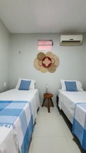um quarto com duas camas e um chapéu na parede em Studio pé na areia com 2 quartos sala cozinha em Trairi