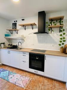 kuchnia z białymi szafkami i blatem w obiekcie Apartamento Rural La Leyenda w mieście El Bosque