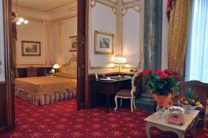 a bedroom with a bed and a desk in a room at Grand Hotel Wagner in Palermo