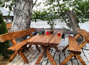 a wooden picnic table and two chairs next to a tree at Apartman na vodi in Belgrade