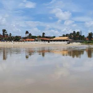 a view of a beach with buildings and the water at Studio pé na areia com 2 quartos, sala e cozinha in Trairi